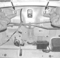 3. Изнутри багажного отделения отпустите два фиксатора и снимите с задней полки