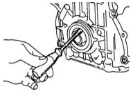Осторожно с помощью отвертки вынуть сальник из крышки привода распредвалов.