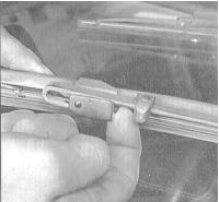 6. Отожмите внутрь стопорный язычок и осторожно снимите щетку с крюка на конце