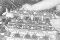 4. Извлеките сборку коромысел с осями из головки цилиндров. Болты крышек подшипников