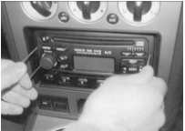 Вставьте в отверстия уголки, отожмите наружу и затем вытащите с прибором из монтажной